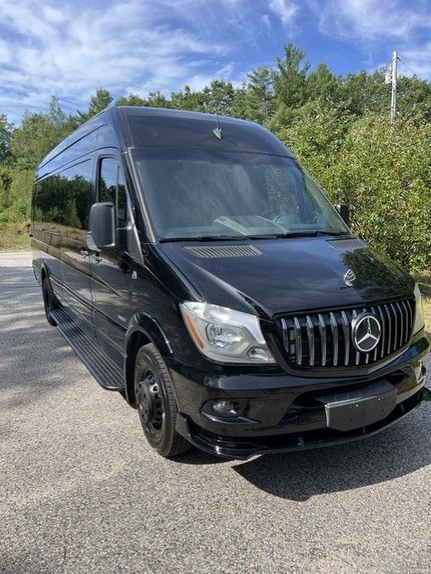 A black mercedes sprinter van is parked on a white background.
