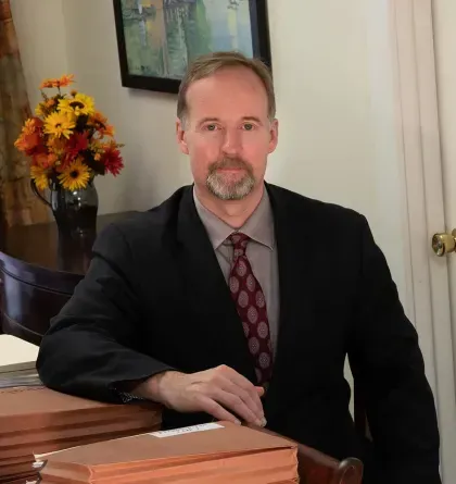 A man in a suit and tie is sitting at a desk