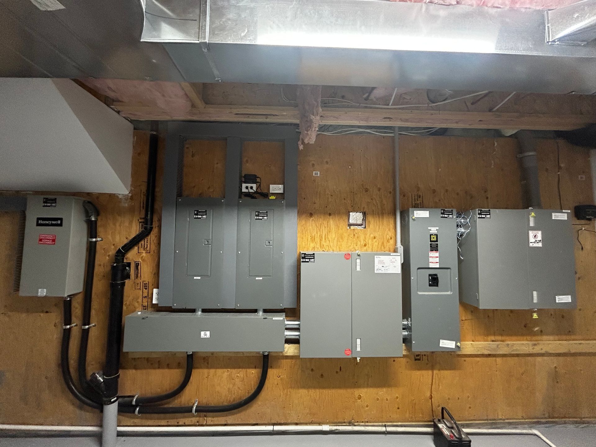 Un tas de boîtes électriques sont accrochées à un mur