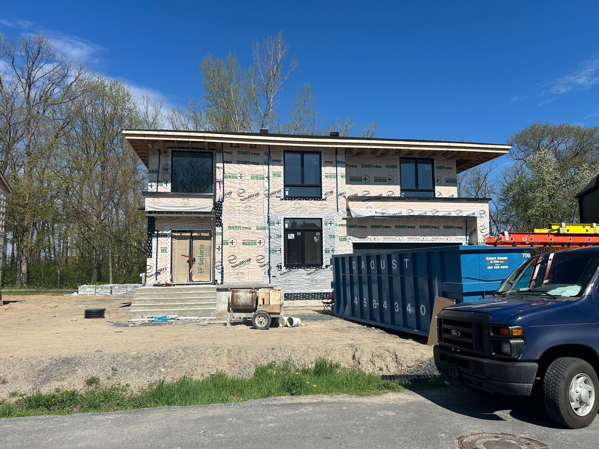 Un camion est garé devant une maison en construction.