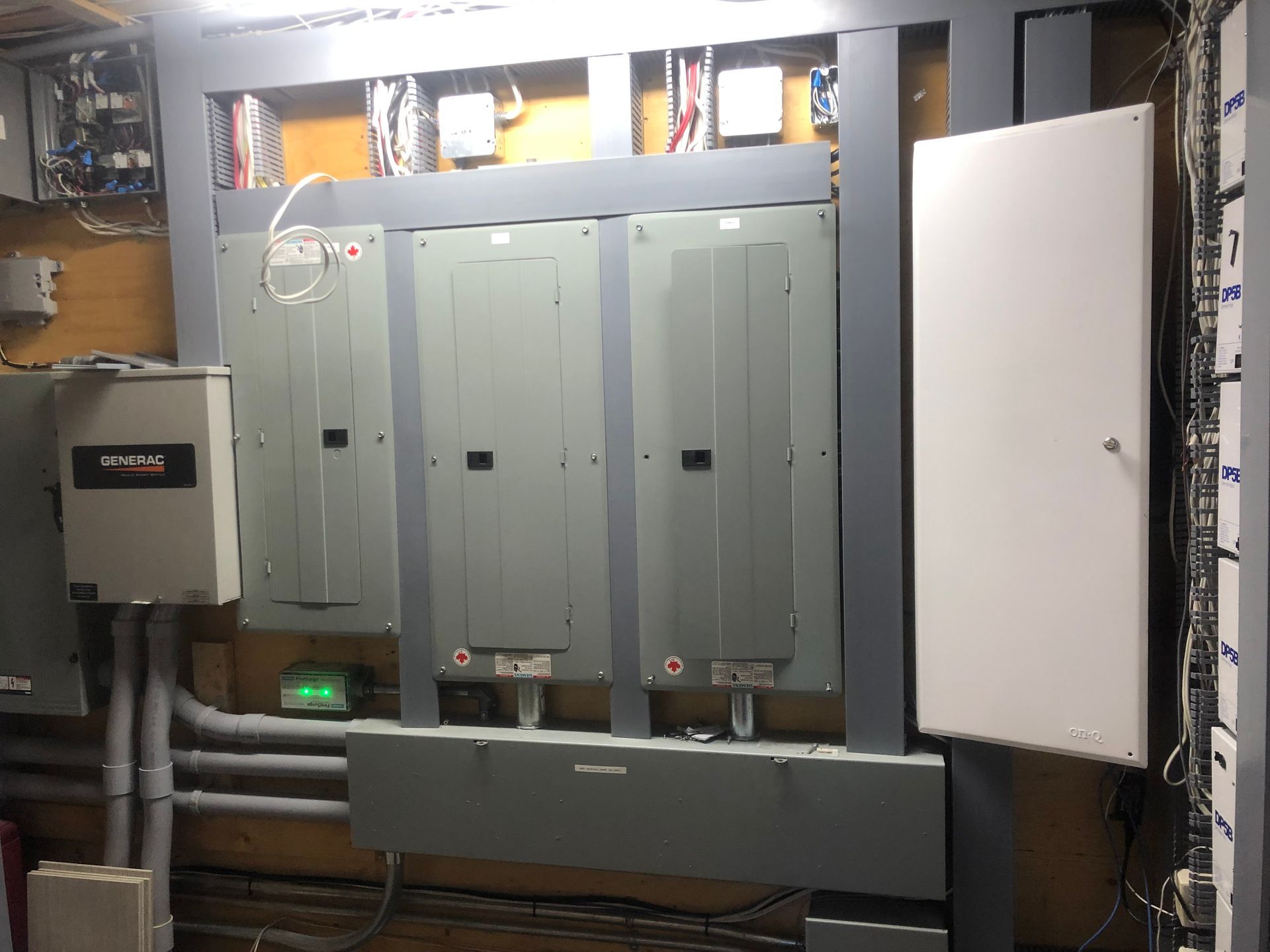 Une pièce avec beaucoup de panneaux électriques et de boîtes sur le mur.