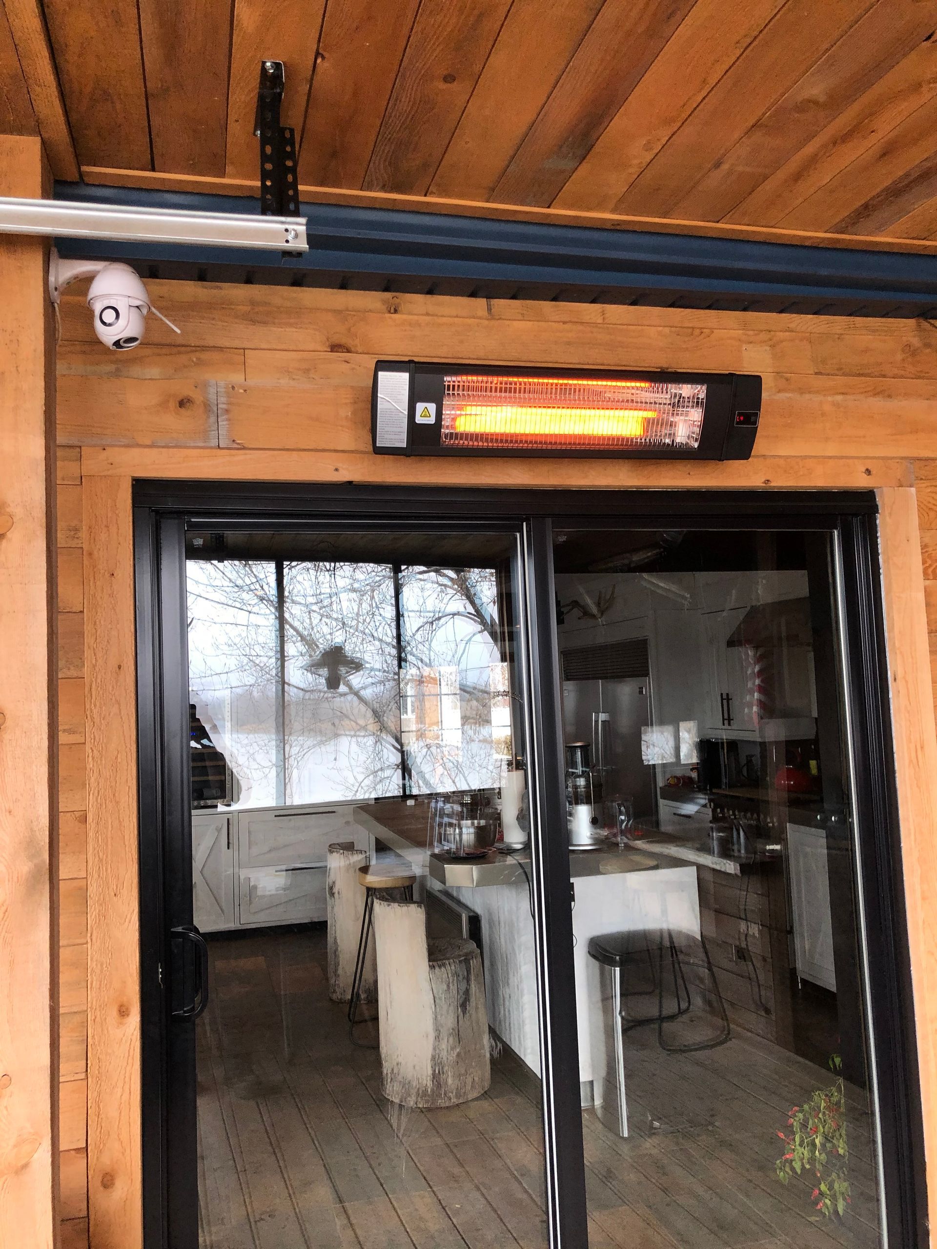 Une pièce avec une porte coulissante en verre et un radiateur suspendu au plafond.