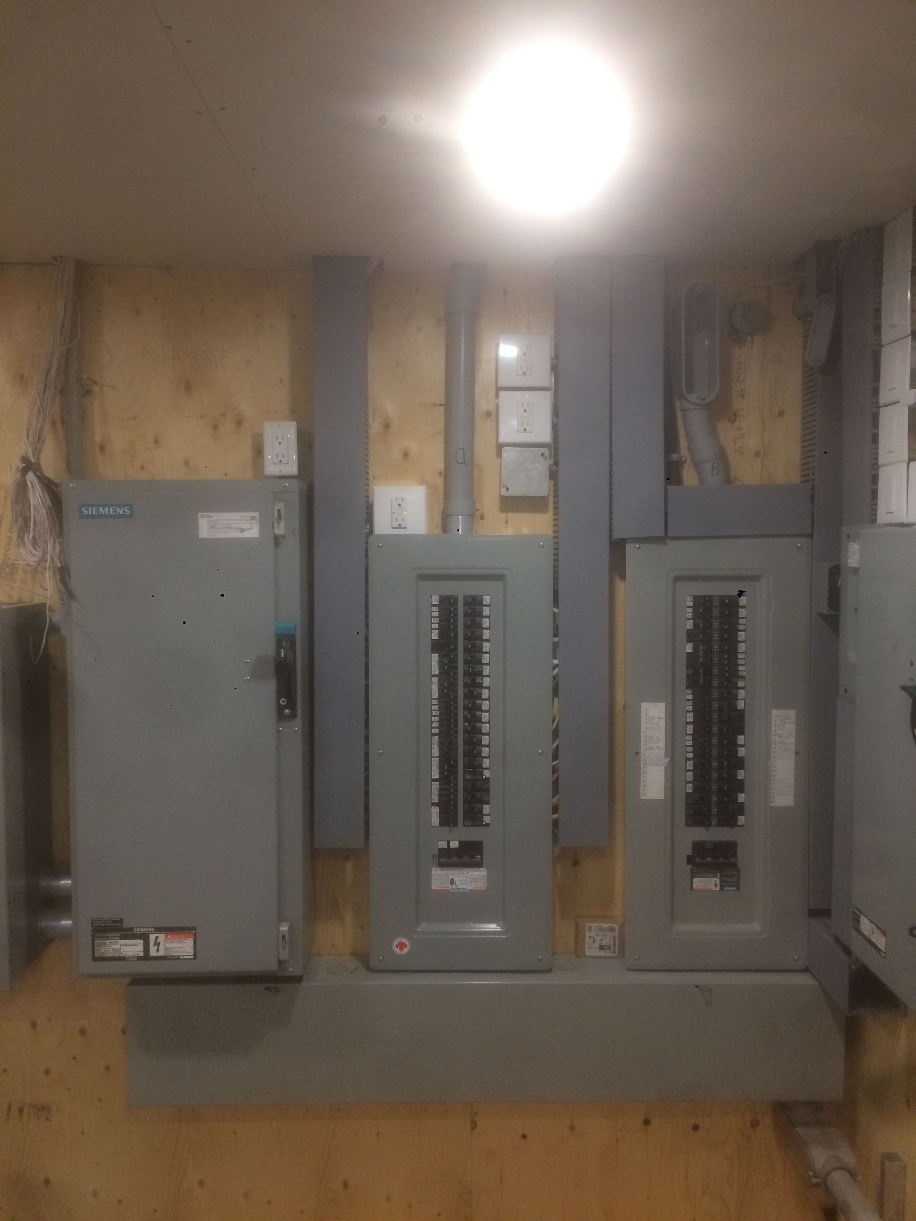 Un tas de panneaux électriques sont accrochés à un mur.