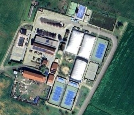 Vista aerea di un complesso sportivo con campi da tennis, campo da calcio, piscina ed edifici.