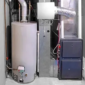 Residential HVAC and water heater equipment in a utility closet with metal ductwork and pipes