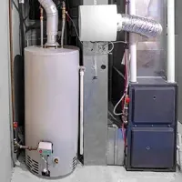 Residential HVAC and water heater equipment in a utility closet with metal ductwork and pipes
