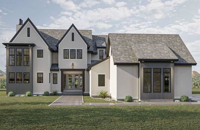 Modern gray two-story house with a front lawn and stone walkway under a cloudy sky