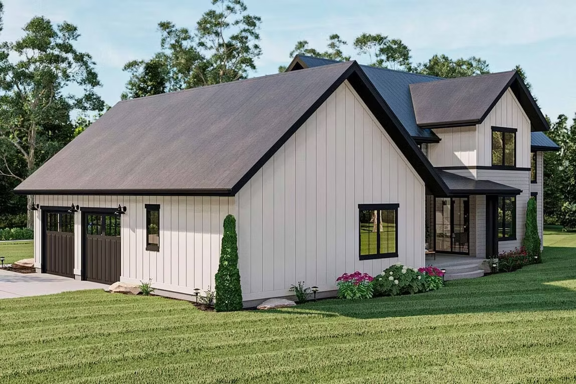 Modern white farmhouse with dark roof, porch, and landscaped lawn under a clear sky