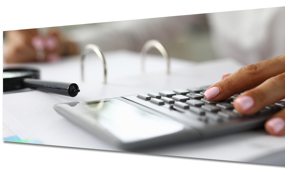 A person is typing on a calculator next to a magnifying glass