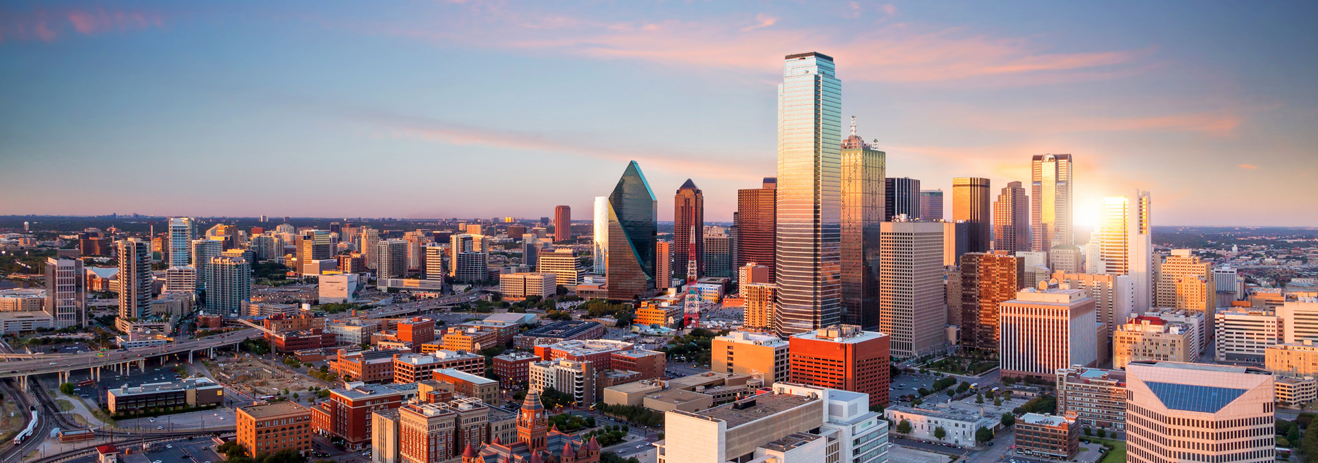 An aerial view of a city skyline at sunset.