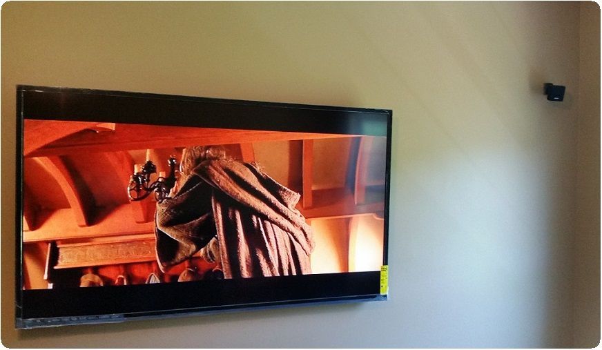 Flat-screen TV mounted on a wall, showing a warm-toned fireplace scene