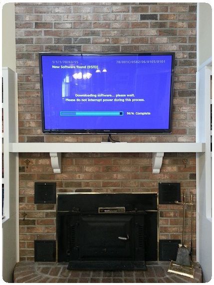 Living room TV displaying a blue system update screen above a brick fireplace