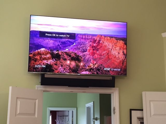 TV mounted above doorway showing a colorful canyon landscape with on-screen text
