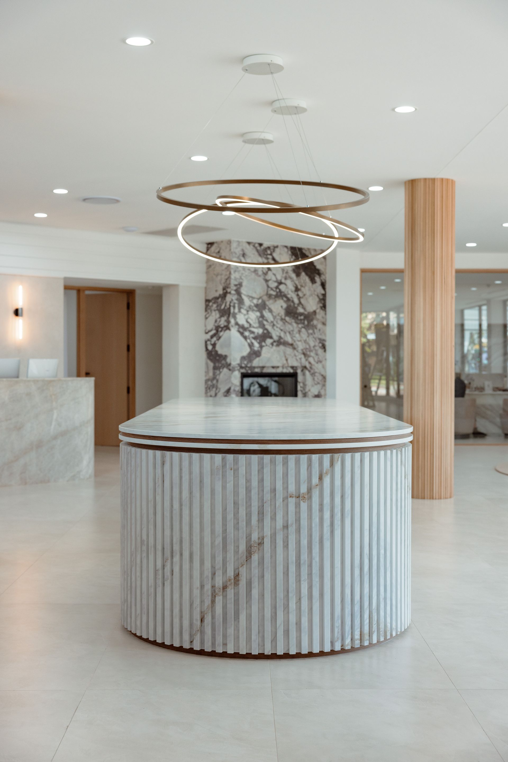 Elegant lobby with marble accents, fireplace, and circular light fixture.