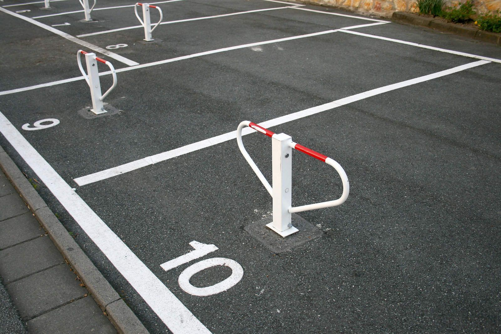 Parking space with white lines and metal barriers; number 10 is visible.