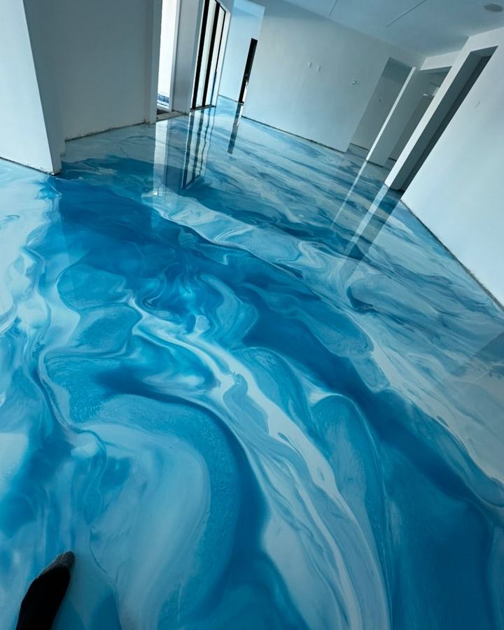 Blue and white marbled epoxy floor in a bright modern hallway with open doors