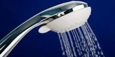 Chrome handheld showerhead spraying water on a blue background