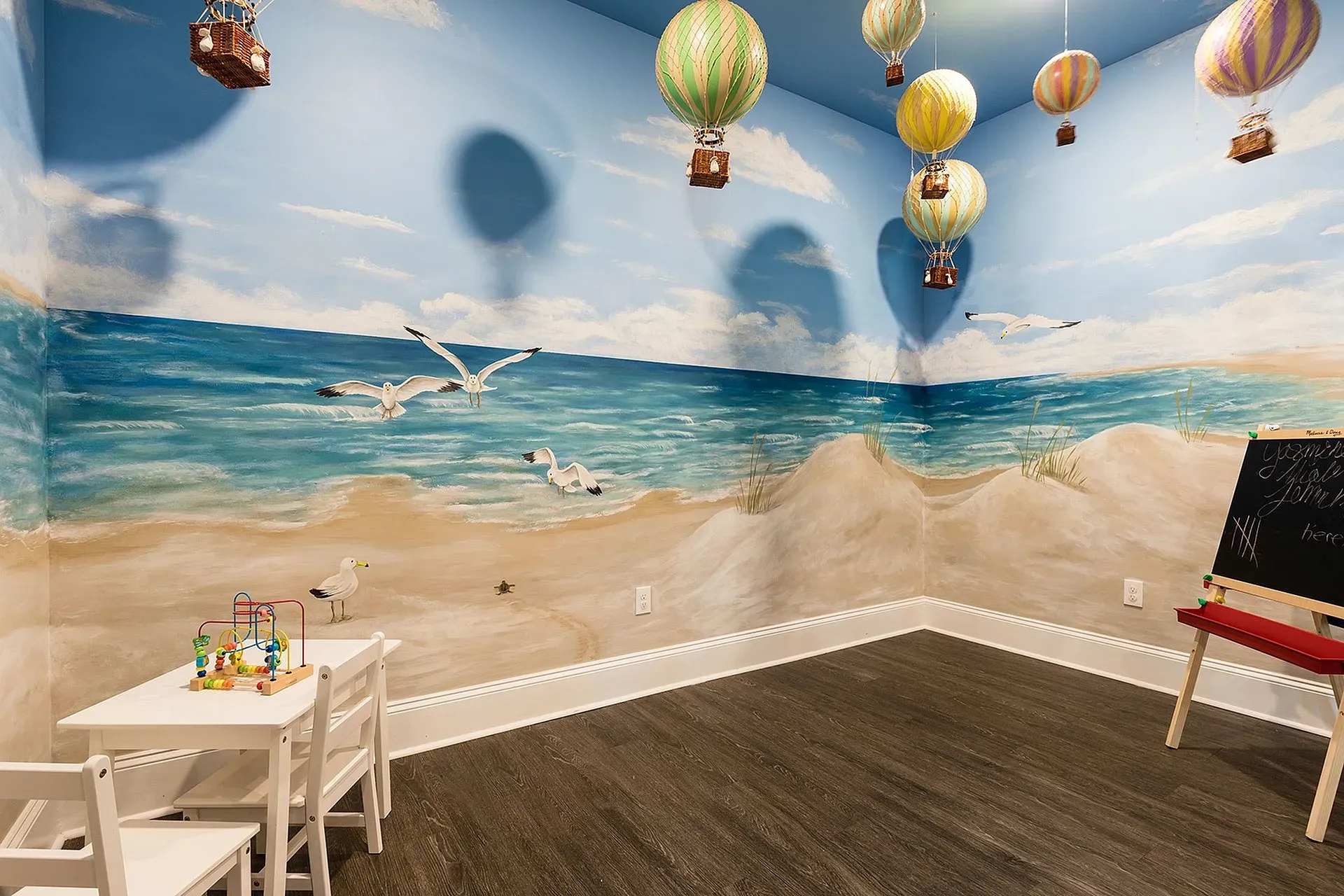 Children's playroom with beach mural, small table and chairs.