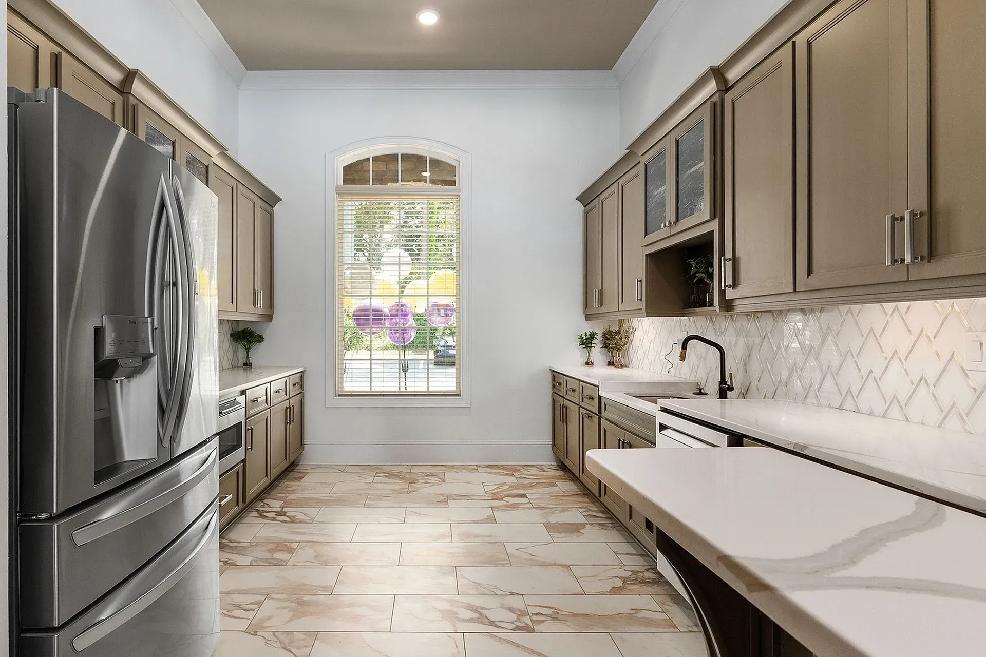 Bright, modern kitchen with stainless steel appliances and white marble countertops.