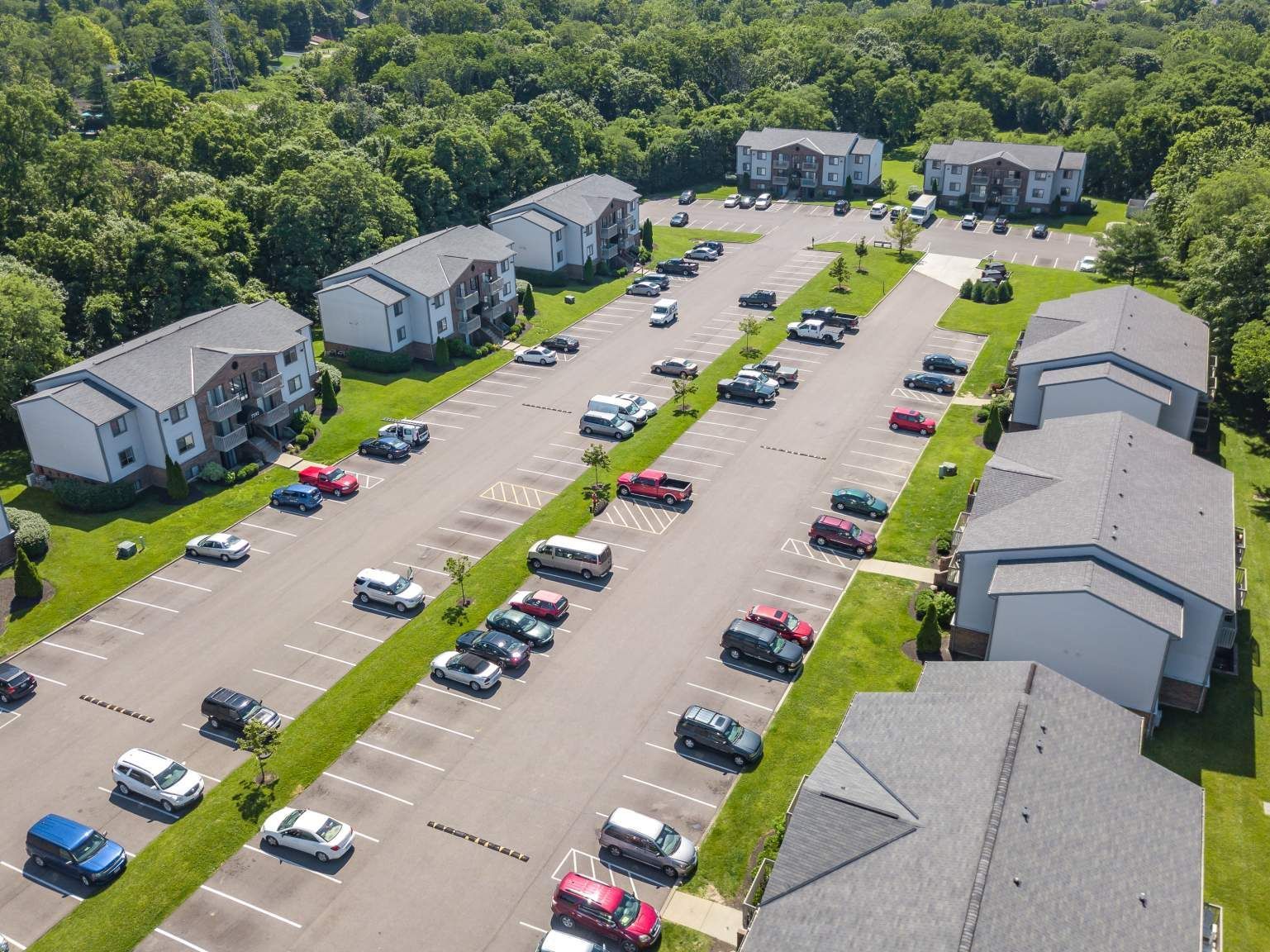 Tall Timber Apartments Aerial view of a multi-building apartment complex with parking lots and green landscaping.