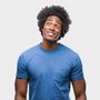 Smiling man in a blue T-shirt looking up against a light background