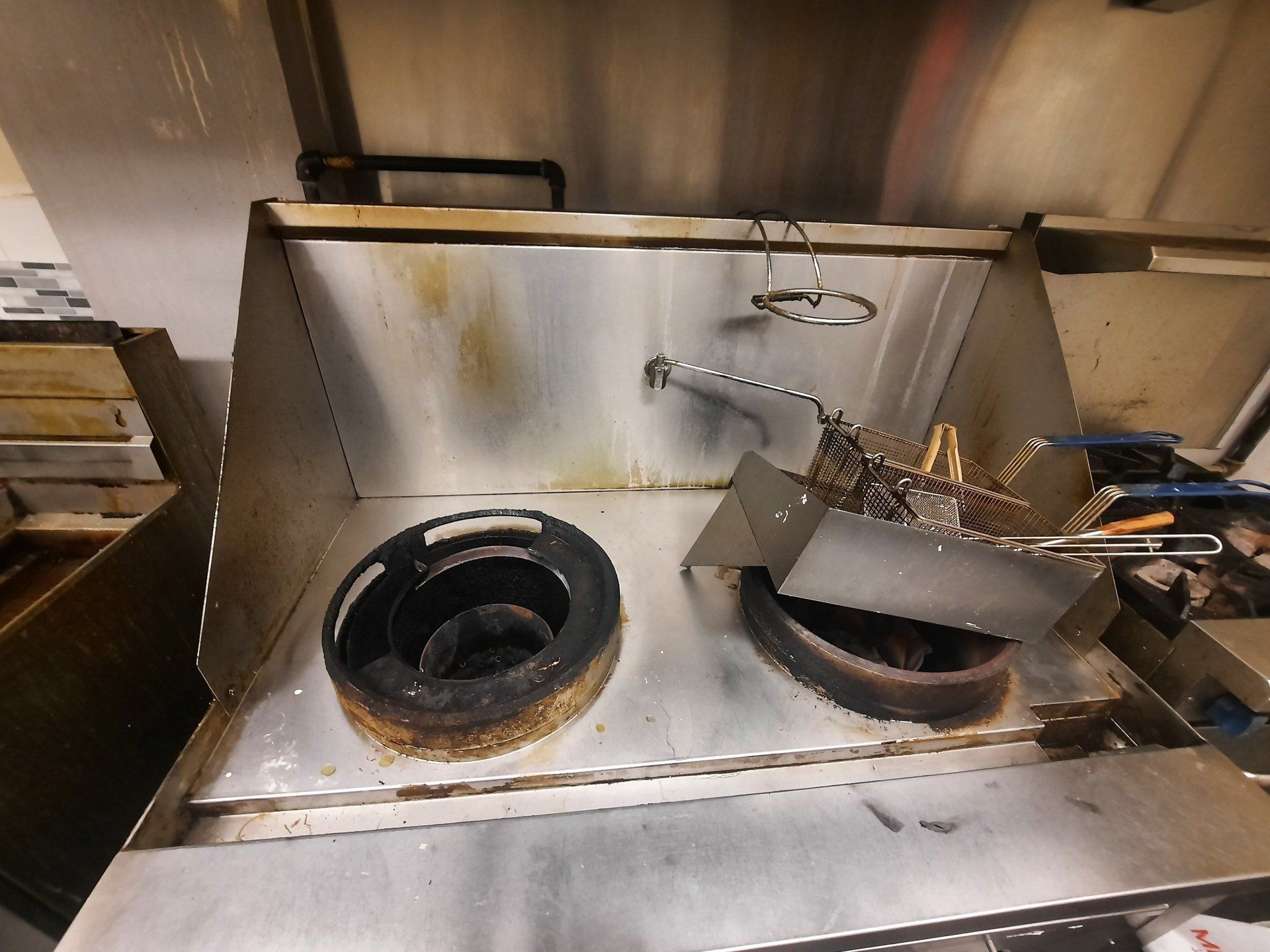 Une cuisinière en acier inoxydable avec deux casseroles dans une cuisine.