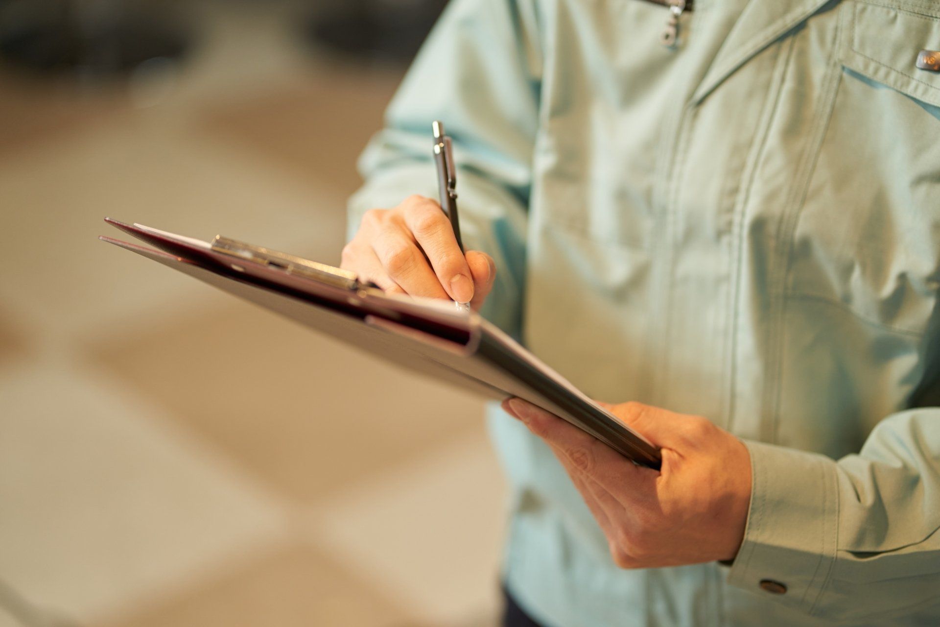 Une personne écrit sur un presse-papiers avec un stylo.