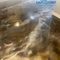 Metallic epoxy flooring, swirling silver and brown tones, reflecting light.