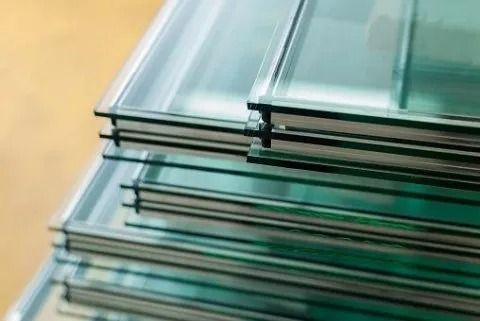 Pannelli di vetro sovrapposti con cornici metalliche su una superficie beige