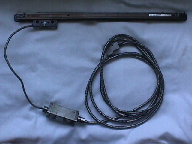 Black wired electronic device with coiled cable and connector on a light blue surface