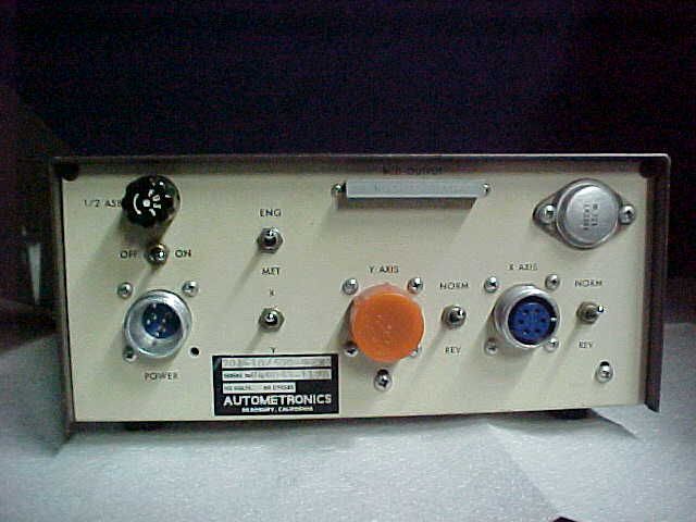 Vintage control panel with knobs, switches, and colored buttons in a metal enclosure