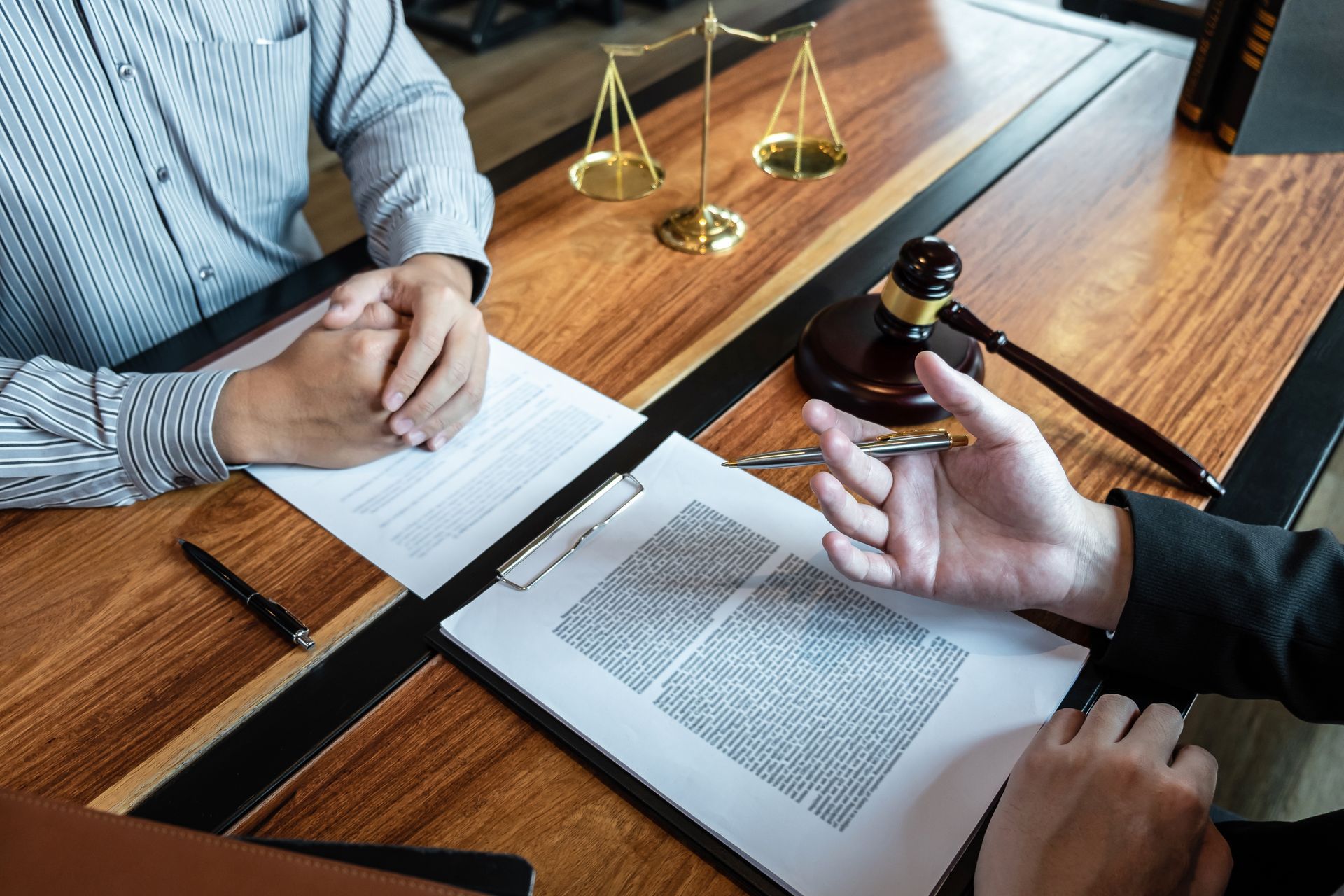 Two people are sitting at a table with papers and a judge 's gavel.