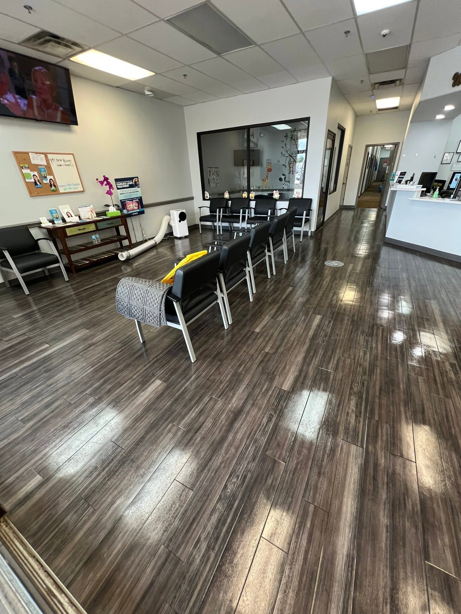 Modern salon interior with glossy dark floors, styling chairs, mirrors, and a waiting bench