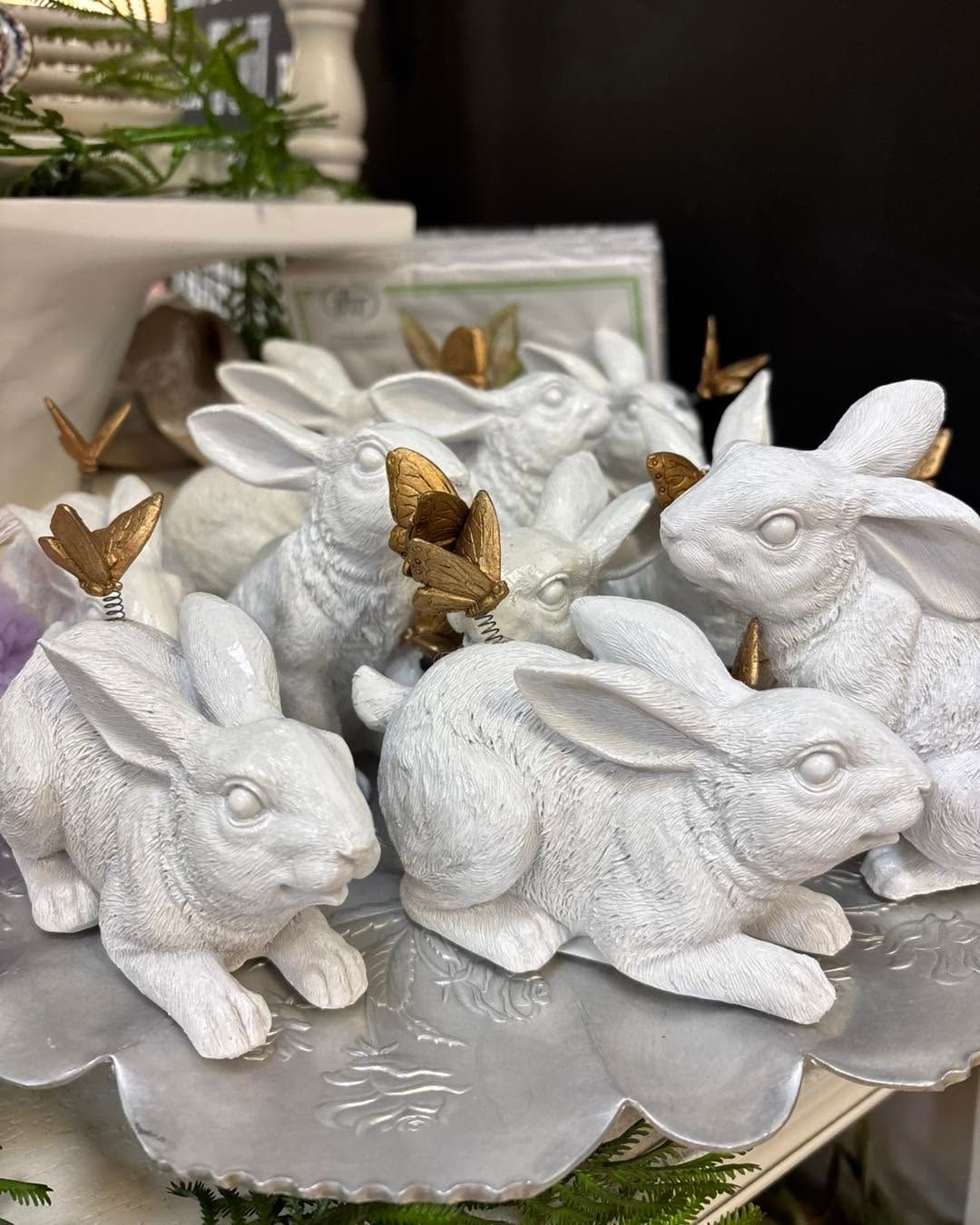 White rabbit figurines with gold butterfly accents on a decorative silver tray