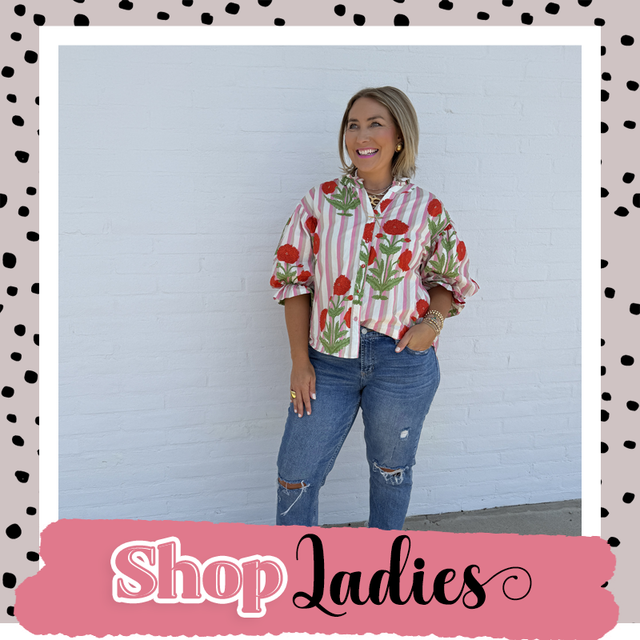 Woman posing in a floral striped shirt and jeans against a white wall with a Shop Ladies banner
