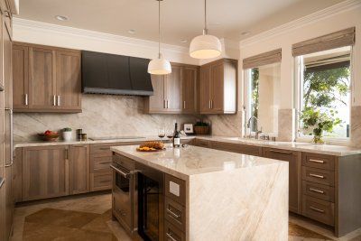 A kitchen with wooden cabinets and a large island in the middle.