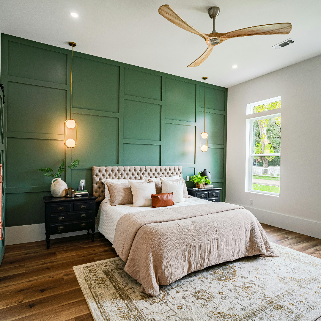 A bedroom with a bed , nightstand , ceiling fan and green walls.