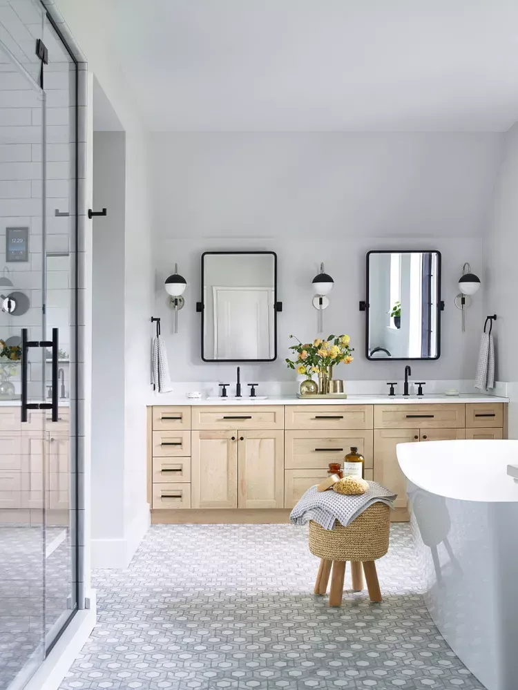 A bathroom with two sinks , a tub , and a shower.