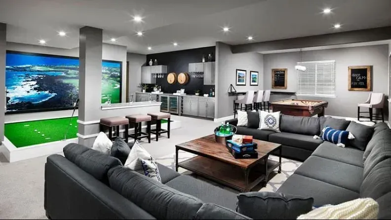 A kitchen with gray cabinets and a large island in the middle.