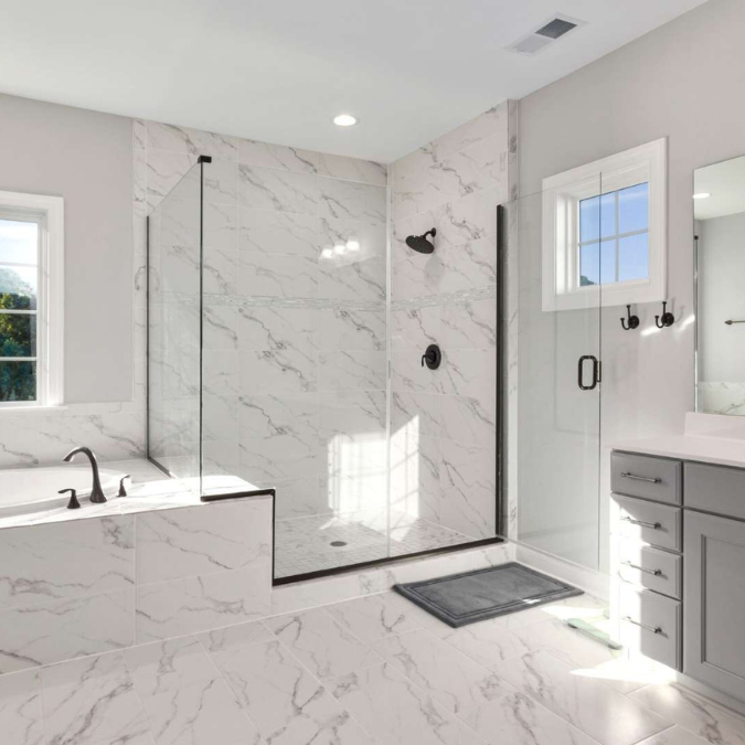 A bathroom with marble walls and a walk in shower