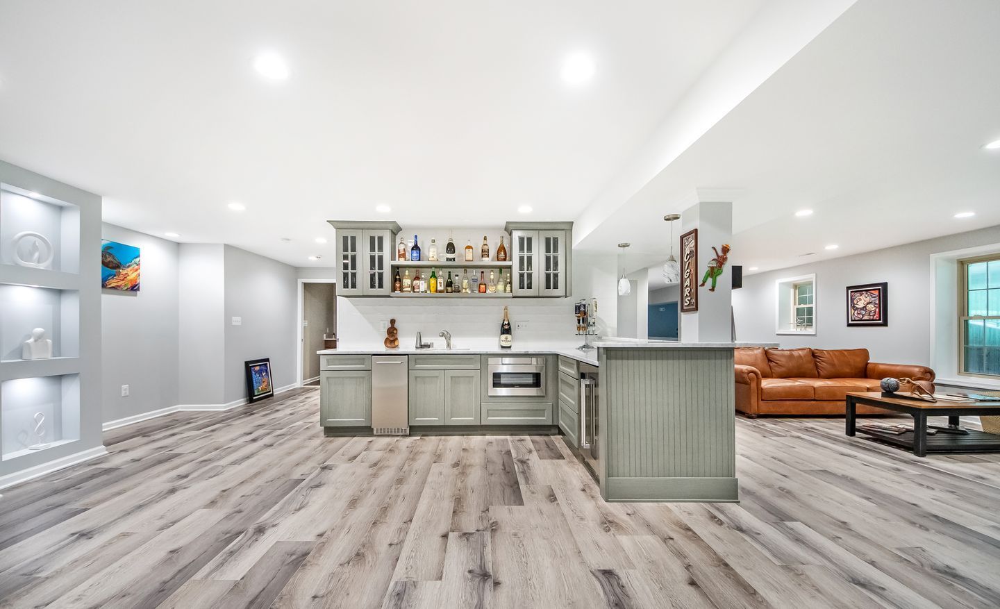 A basement with a kitchen , living room , and bar.