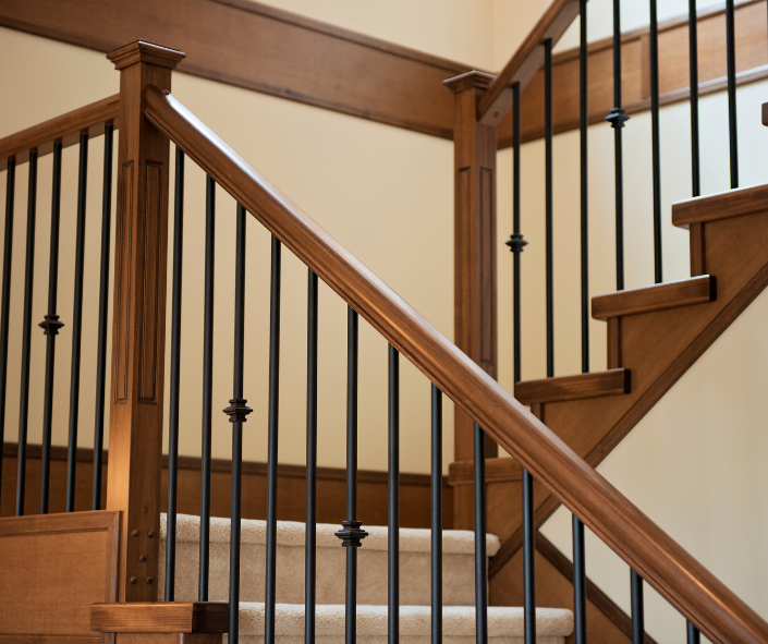 A wooden staircase with black metal railings