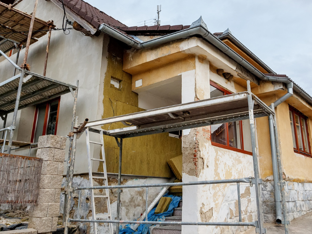 A house is being remodeled with scaffolding around it.