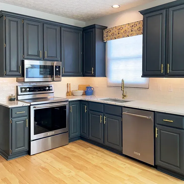 A kitchen with stainless steel appliances and gray cabinets