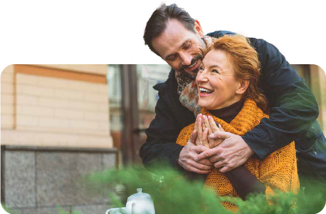 A man is hugging a woman while sitting at a table.