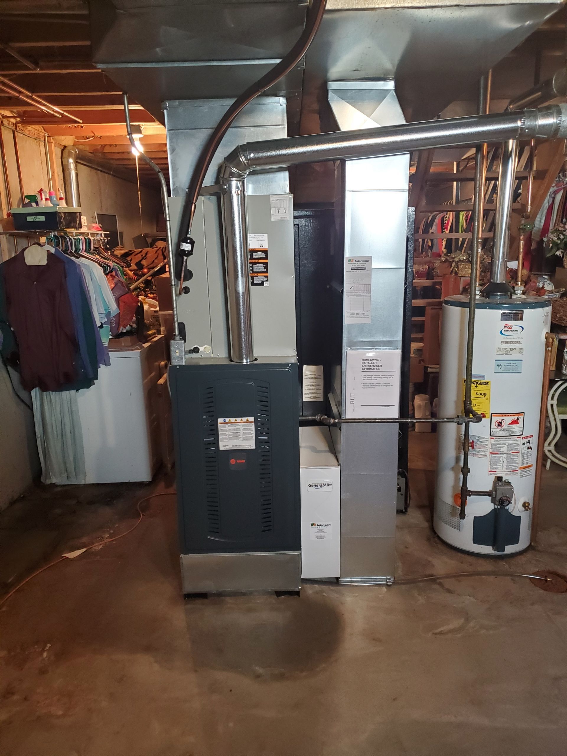 A basement with a washer and dryer and a water heater.