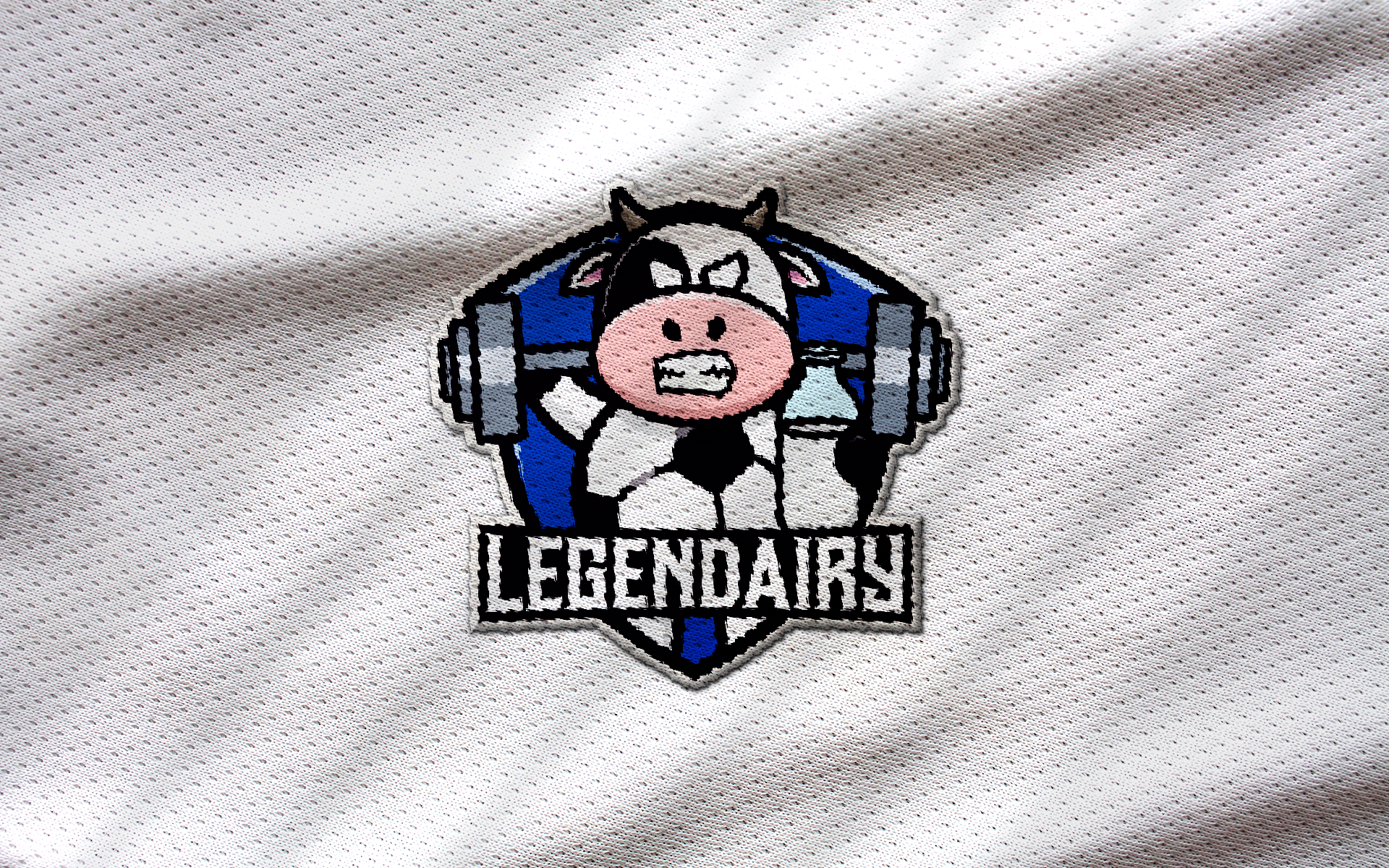 Embroidery of 'Legendairy' sports team logo featuring a cartoon cow lifting weights on a white textured fabric background.