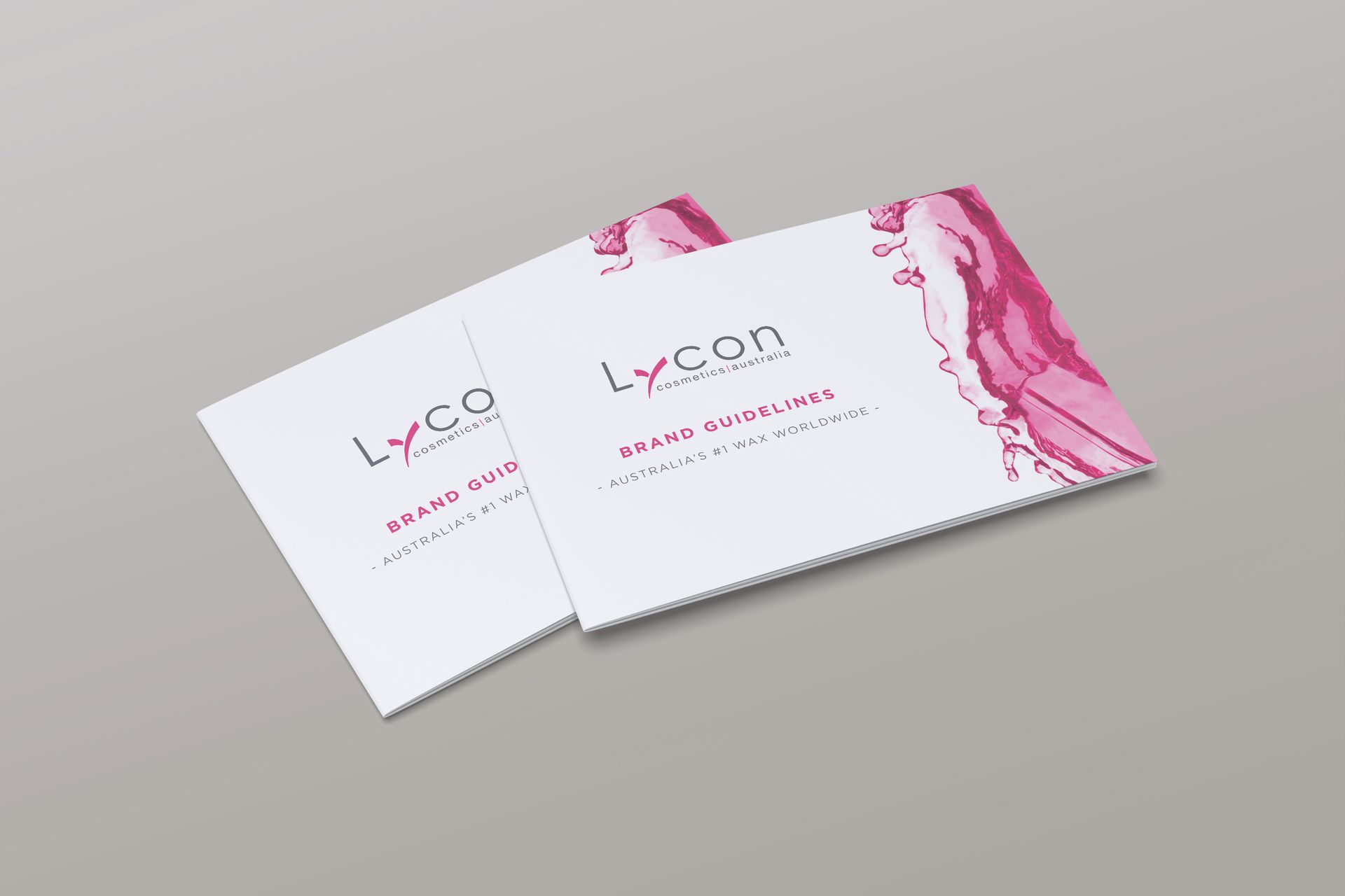 Two business cards are stacked on top of each other on a table.
