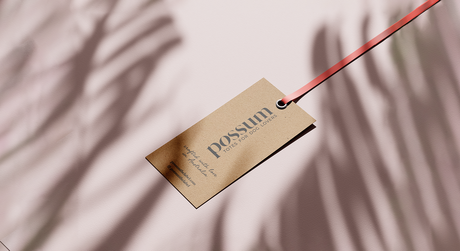 A tag is hanging from a red string on a pink cloth.