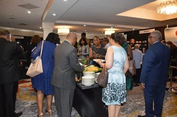People gathered around a buffet table at a formal indoor reception.